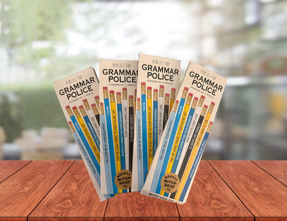 Four packs of “Pencils for Grammar Police” displayed on a wooden table, featuring blue and yellow No. 2 pencils printed with funny grammar quotes.