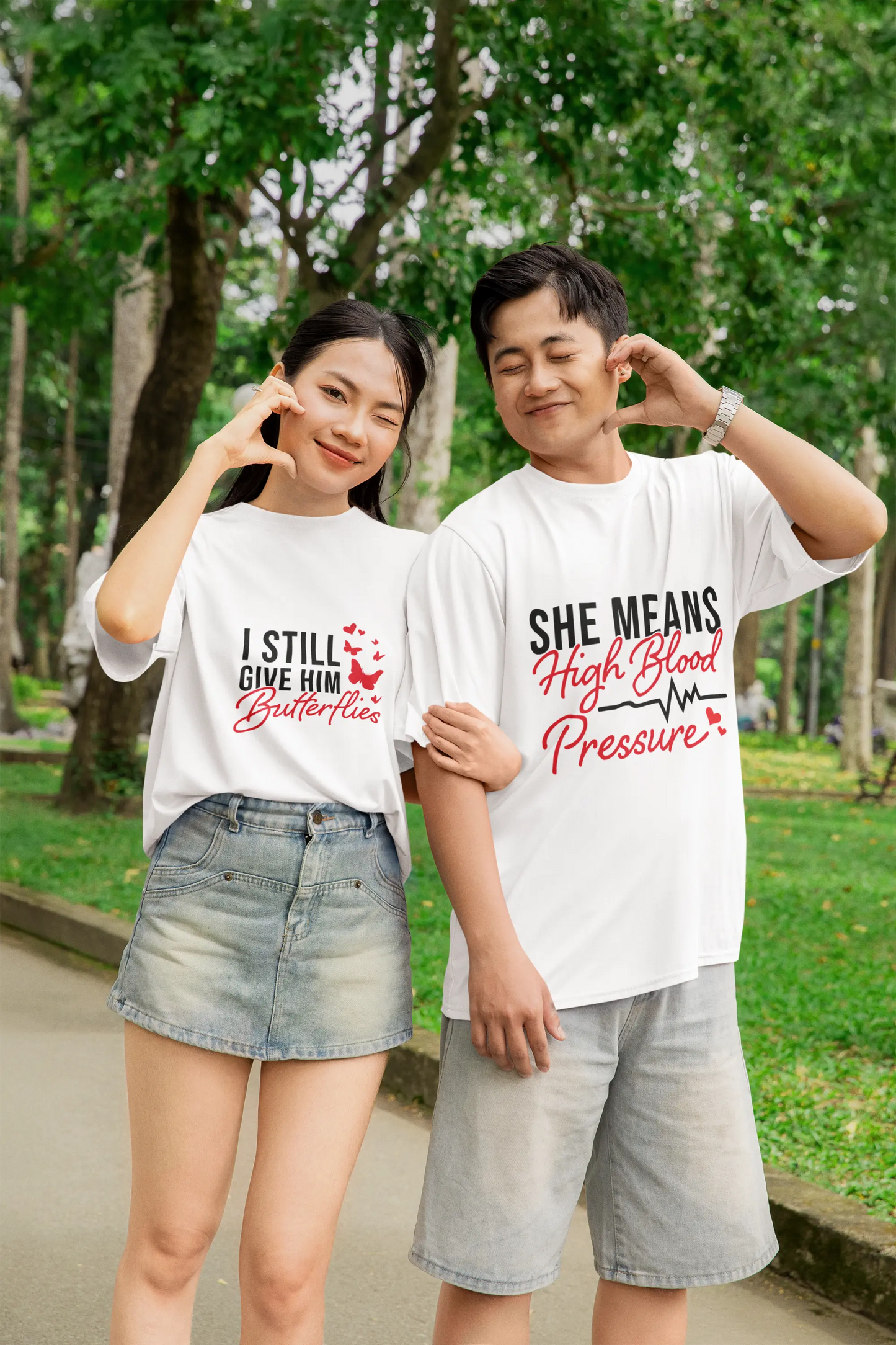 Funny Valentine’s Day couples wearing matching t-shirts reading “I still give him butterflies” and “She means high blood pressure”