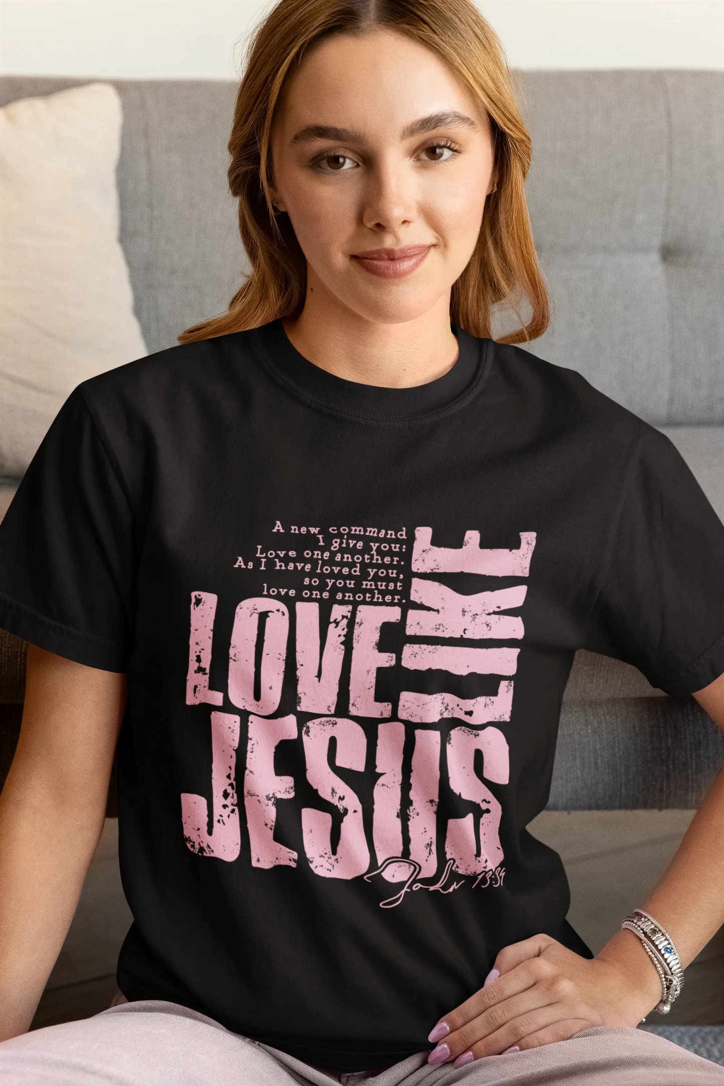 Girl wearing black shirt with pink writing that says love like Jesus