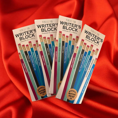 Four packs of “Pencils for The Office” displayed on a wooden table, featuring humorous office-life themed No. 2 pencils.