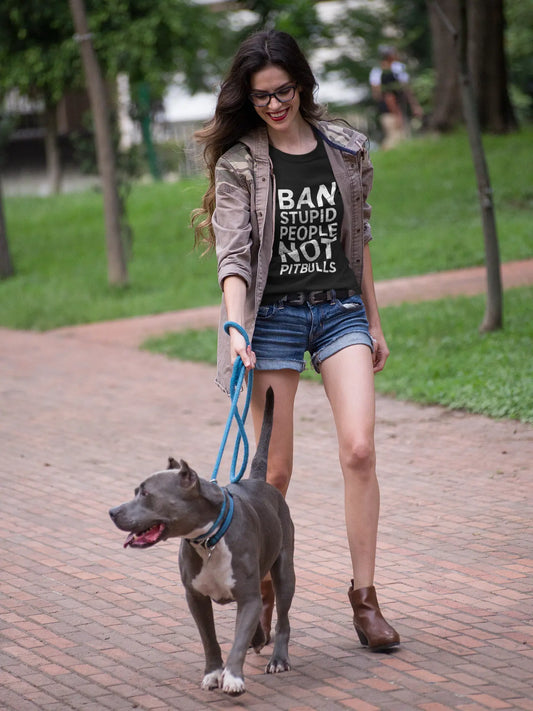 Lady wearing a black tshirt with a leash on a pit bull and the tshirt says "Ban Stupid People, Not Pittbulls"